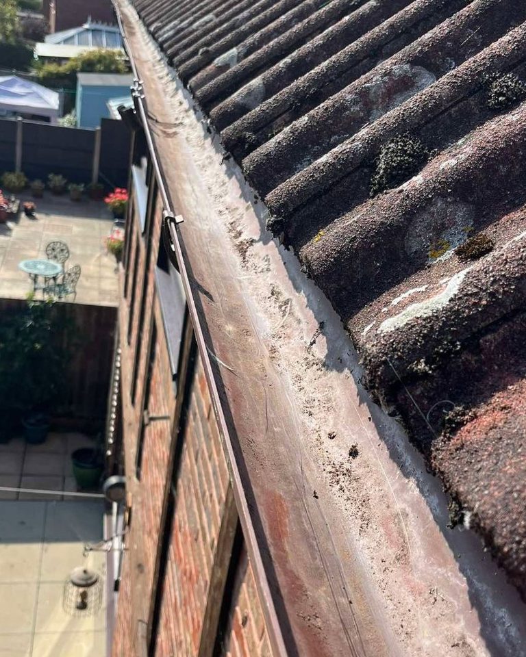 The same gutter after clearing, empty and free to drain