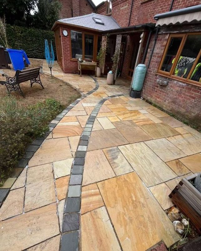 The same sandstone patio and path after cleaning, warm golden colours restored