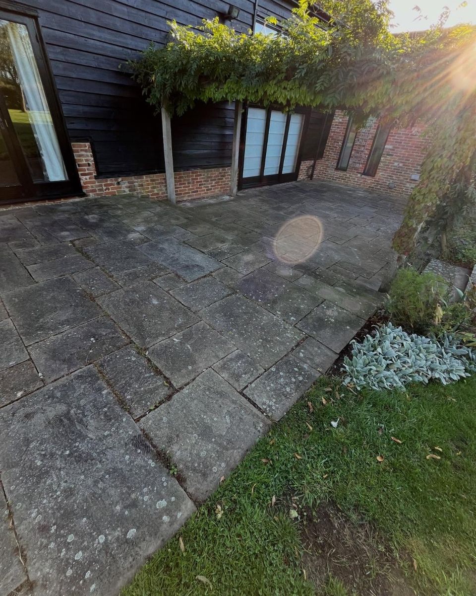 Indian sandstone patio before cleaning, grey with moss and white lichen spots