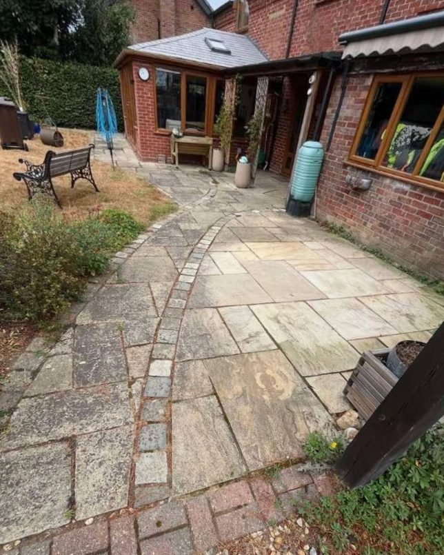 Sandstone patio and curved path, grey and stained before cleaning