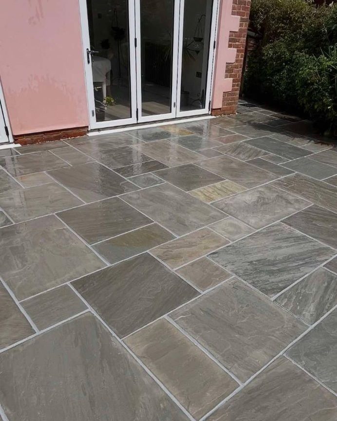 Grey Indian stone patio outside bifold doors, freshly cleaned with crisp new pointing