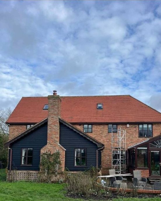 The same house after roof cleaning, its clay tiles back to a bright terracotta red